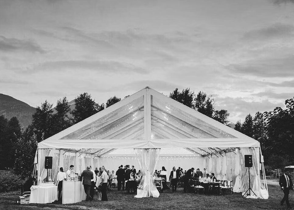 Clear top frame tent lit up for an evening wedding